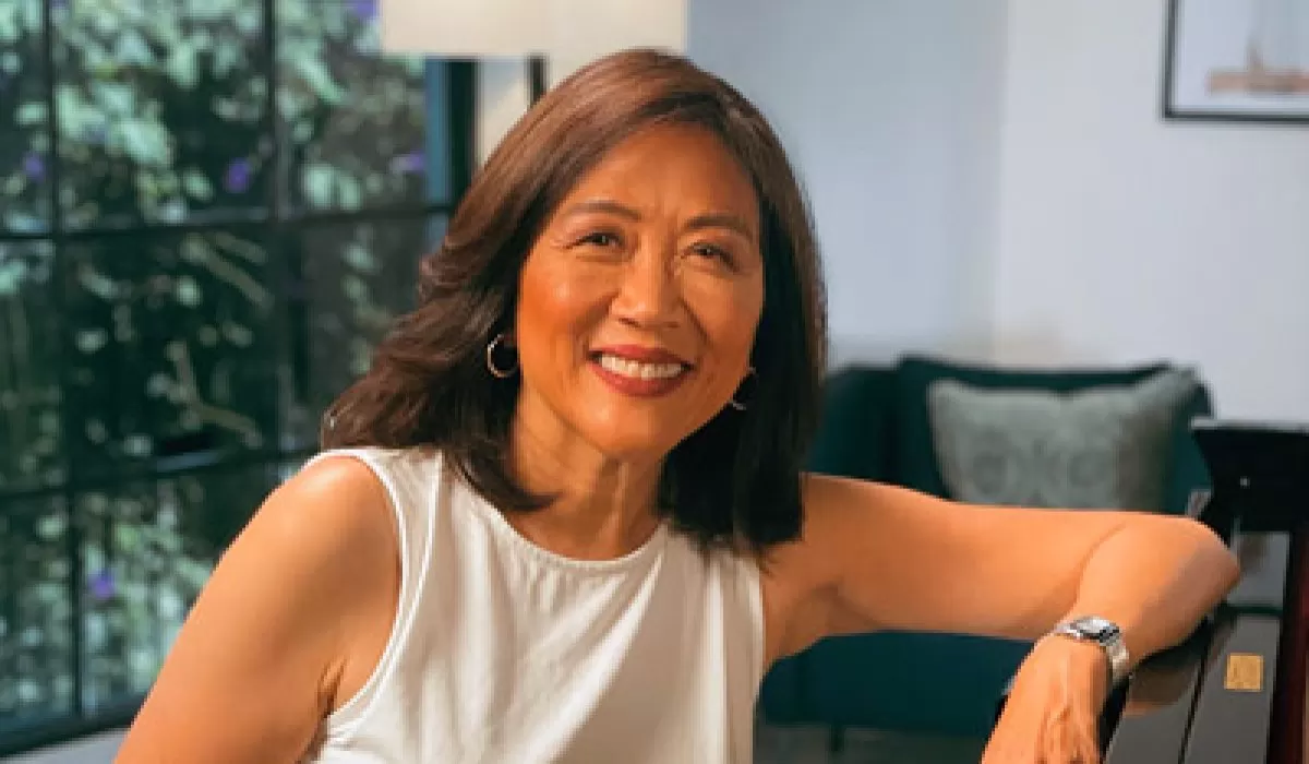 Portrait of a smiling woman seated indoors.