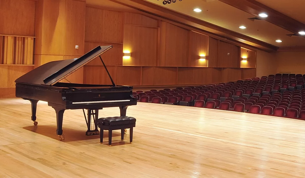 Grand piano sitting open on wooden stage in Grusin Music Hall.