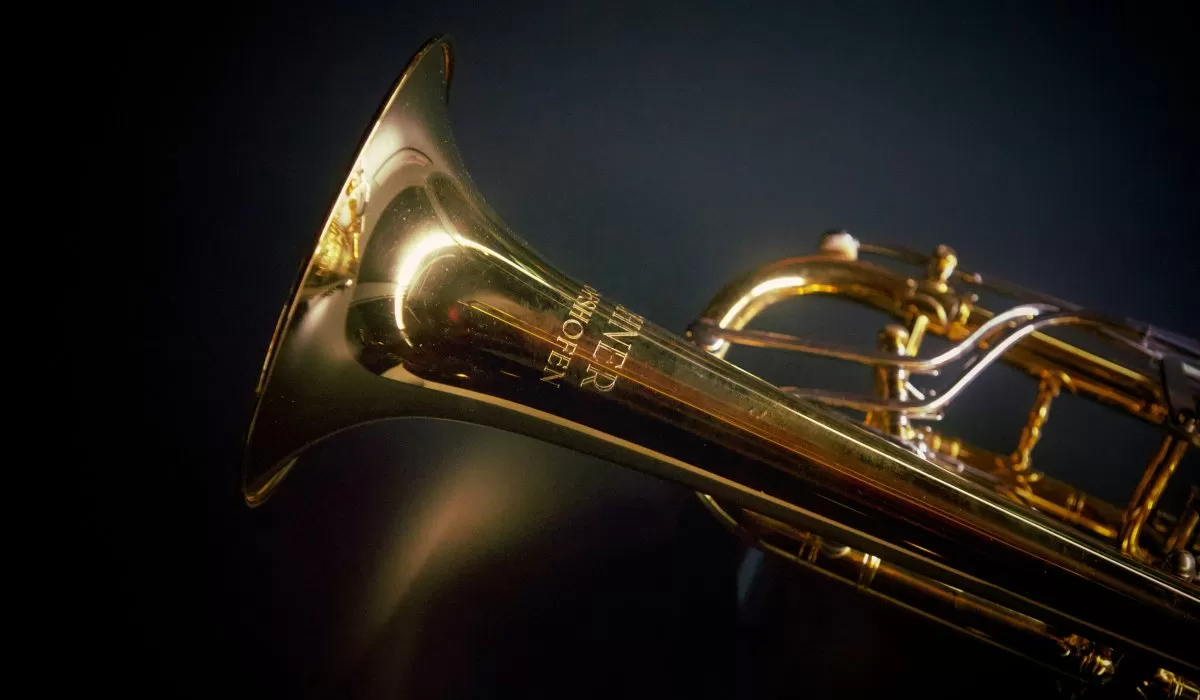 Close-up of a brass saxophone against a dark background.