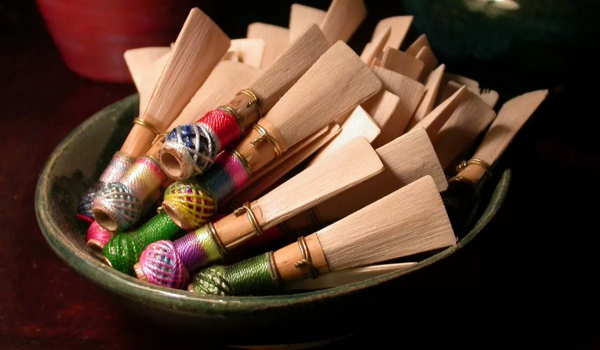 Bowl filled with colorful, handmade wooden percussion instruments.