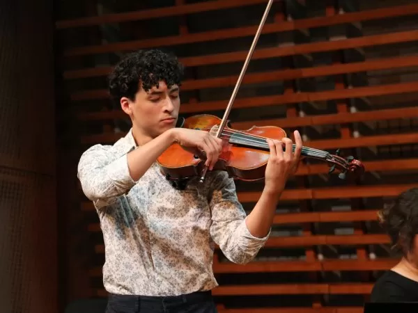 Young man in white shirt playing viola.