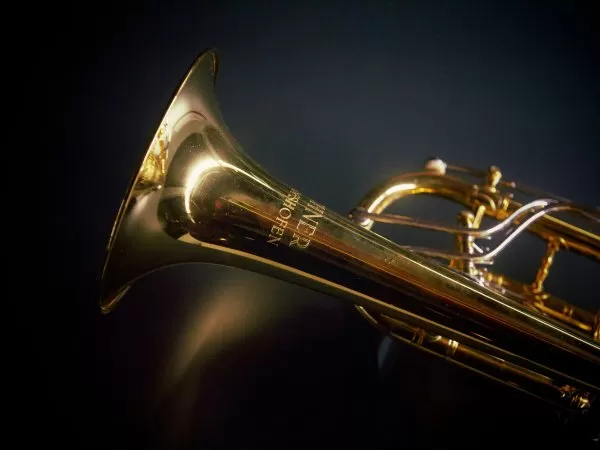 Close-up of a brass saxophone against a dark background.