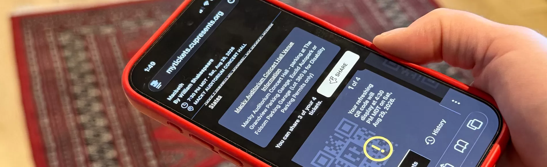 Hand holding iphone with digital ticket displaying